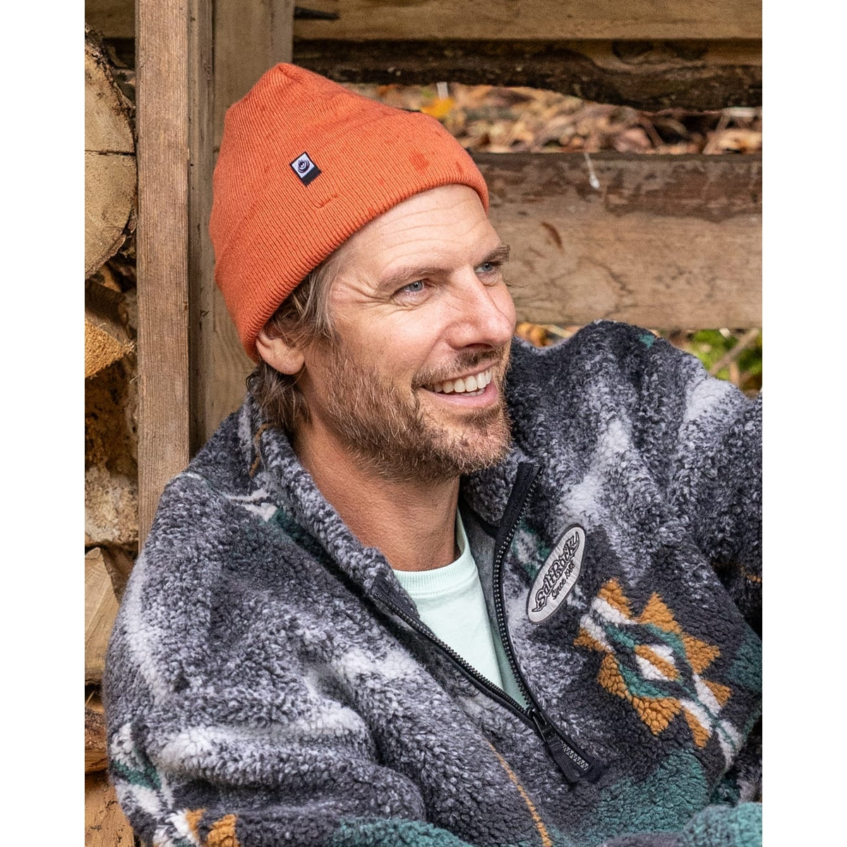 A man wearing a Saltrock OK beanie in light orange, with turn back hem and small logo label.