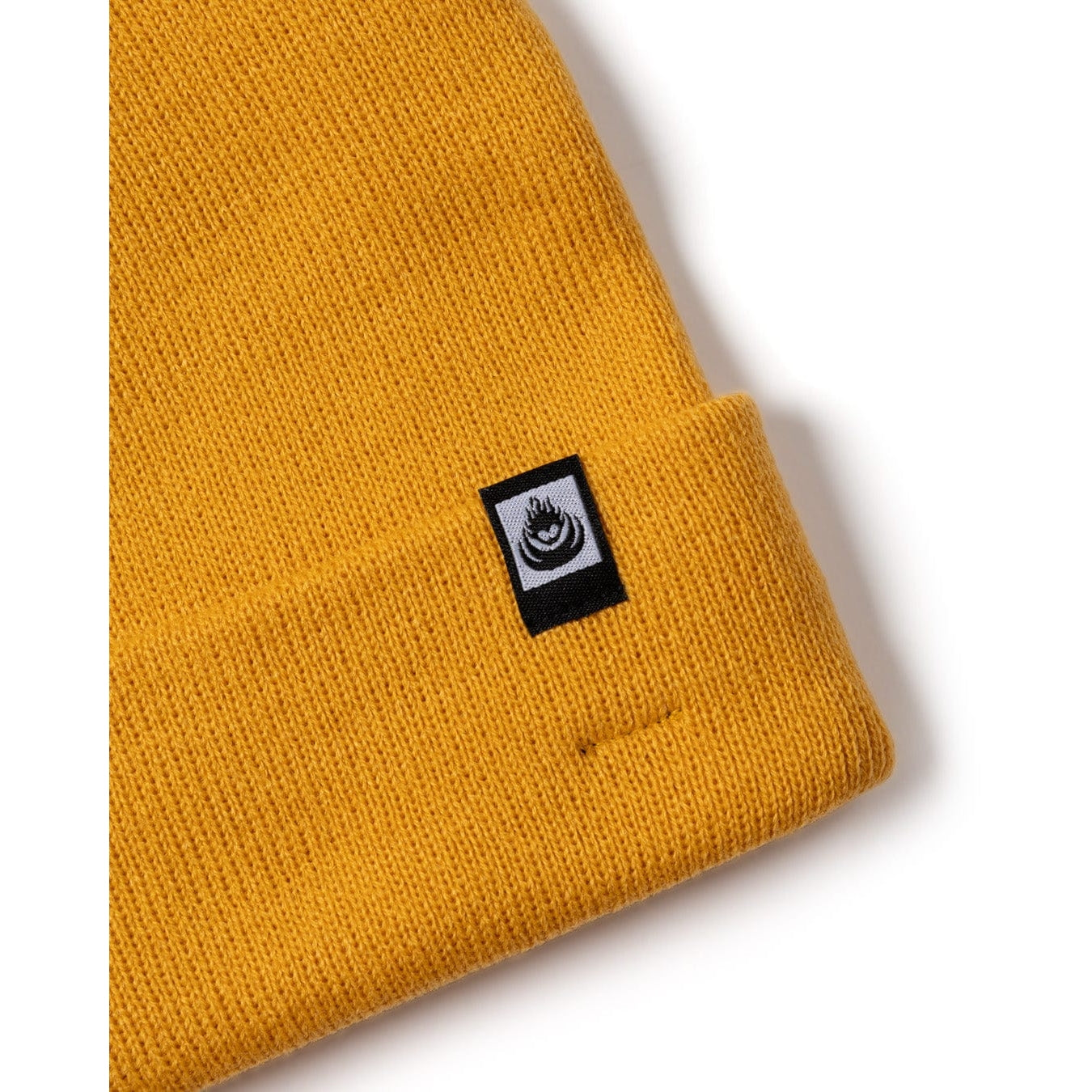 Yellow Saltrock knit beanie with a black  logo label on a white background
