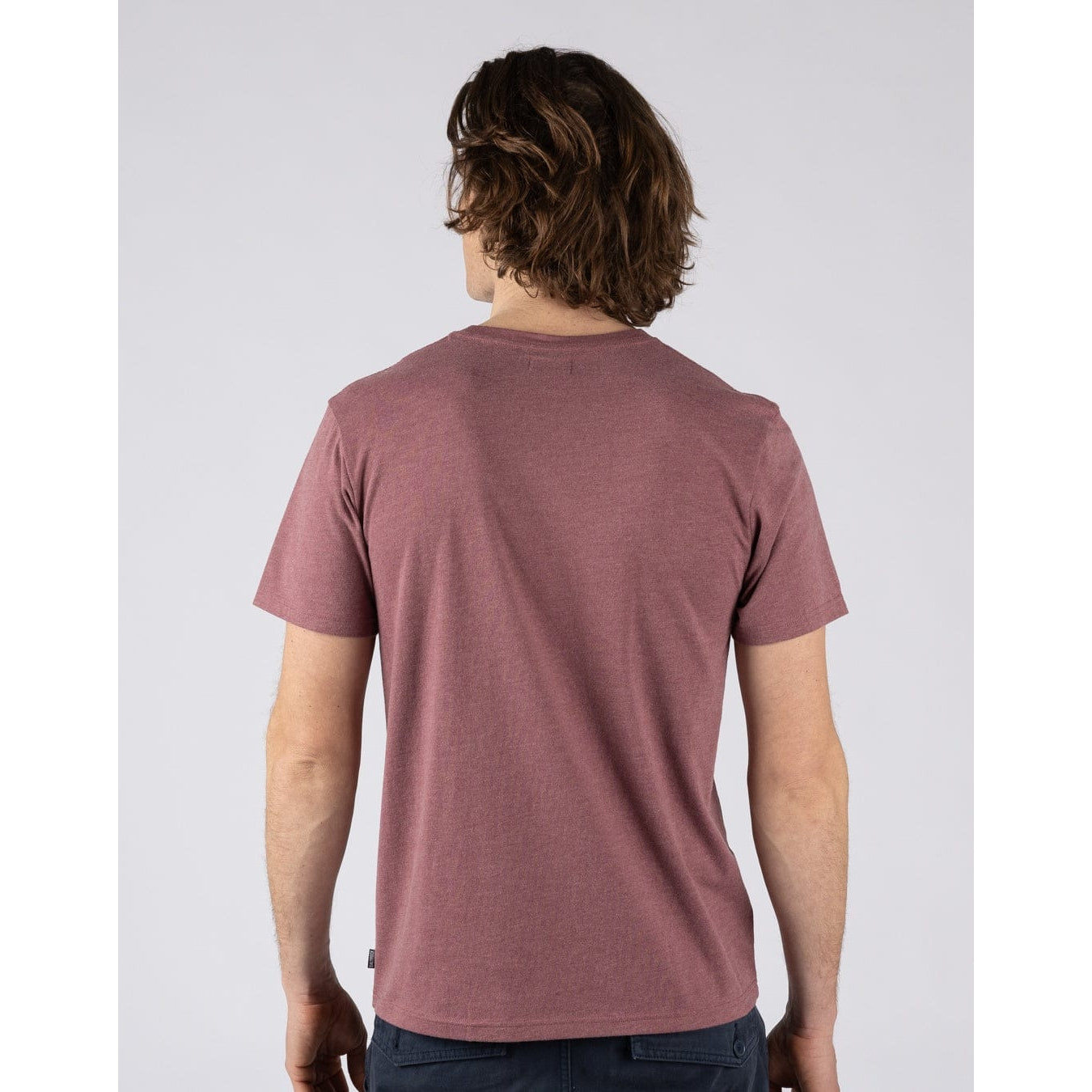 Back view of a man wearing a Saltrock short sleeve Essential crew neck t-shirt in dark pink with a small logo on the chest