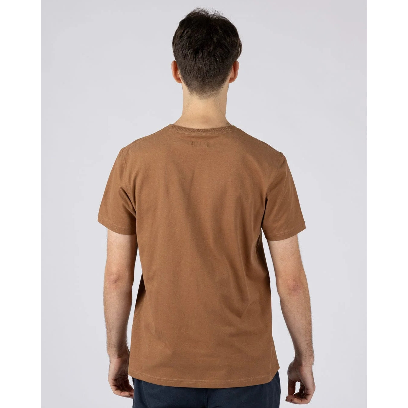 Back view of a man wearing a Saltrock short sleeve Trail Bus print t-shirt in brown