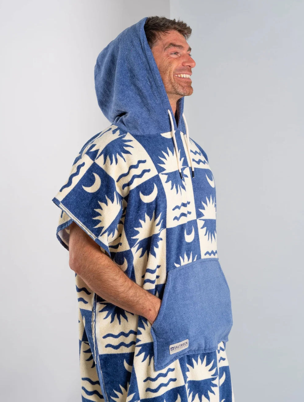 Saltrock changing towel robe blue with sun and wave pattern worn by smiling man with hood