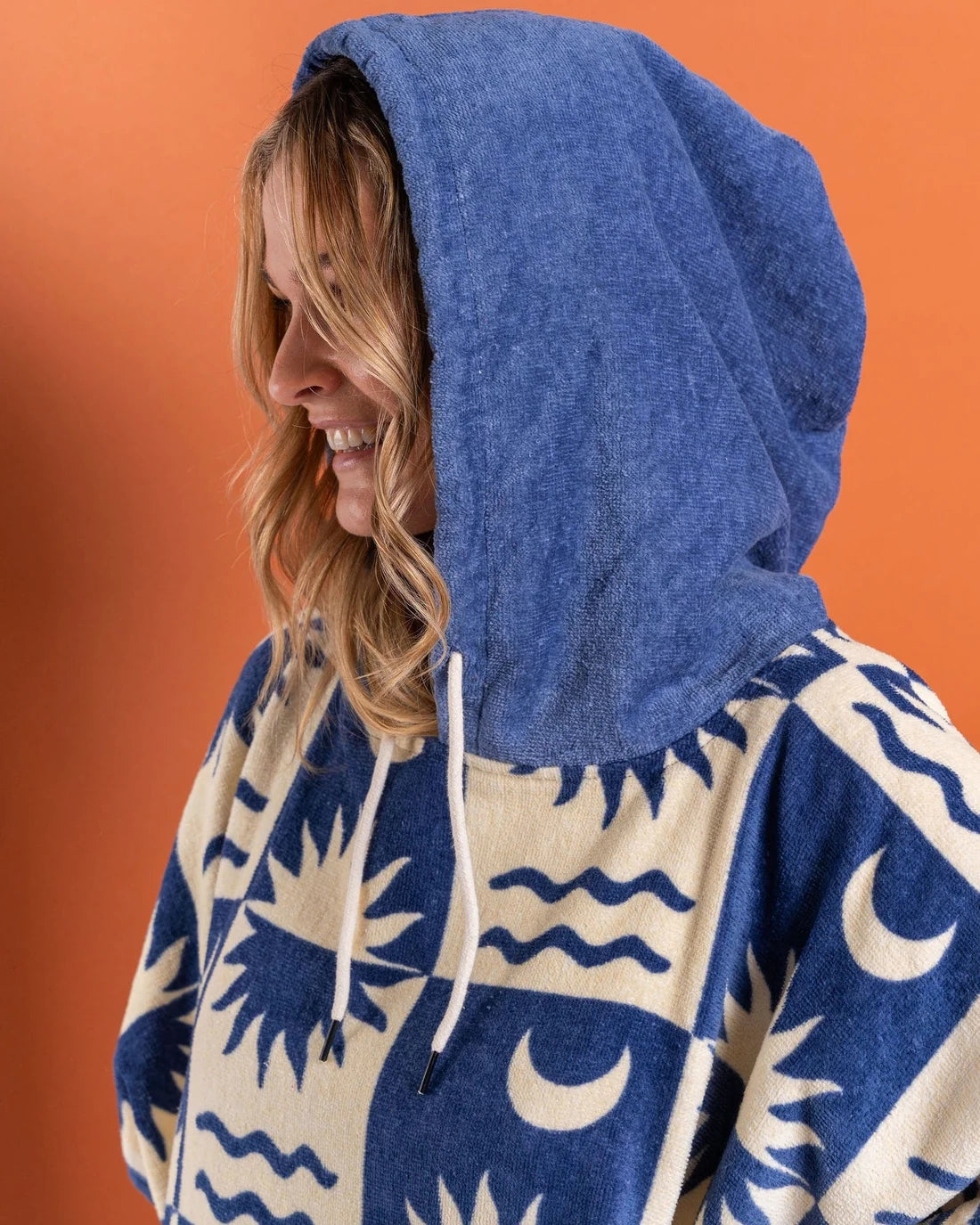 Saltrock changing towel robe blue with hood featuring sun and moon patterns worn by smiling woman
