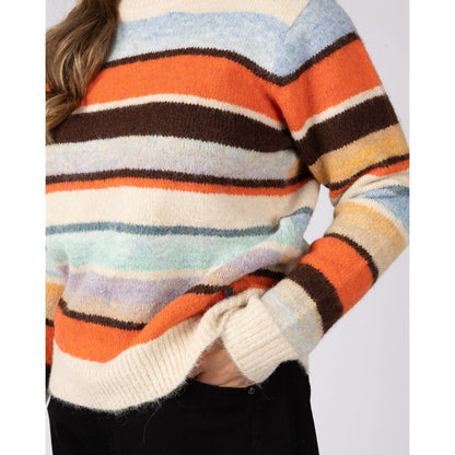Close-up view of a cuff and the hem of a woman wearing a Saltrock Lyris crew neck knitted jumper in an orange, cream and multicolour striped pattern.