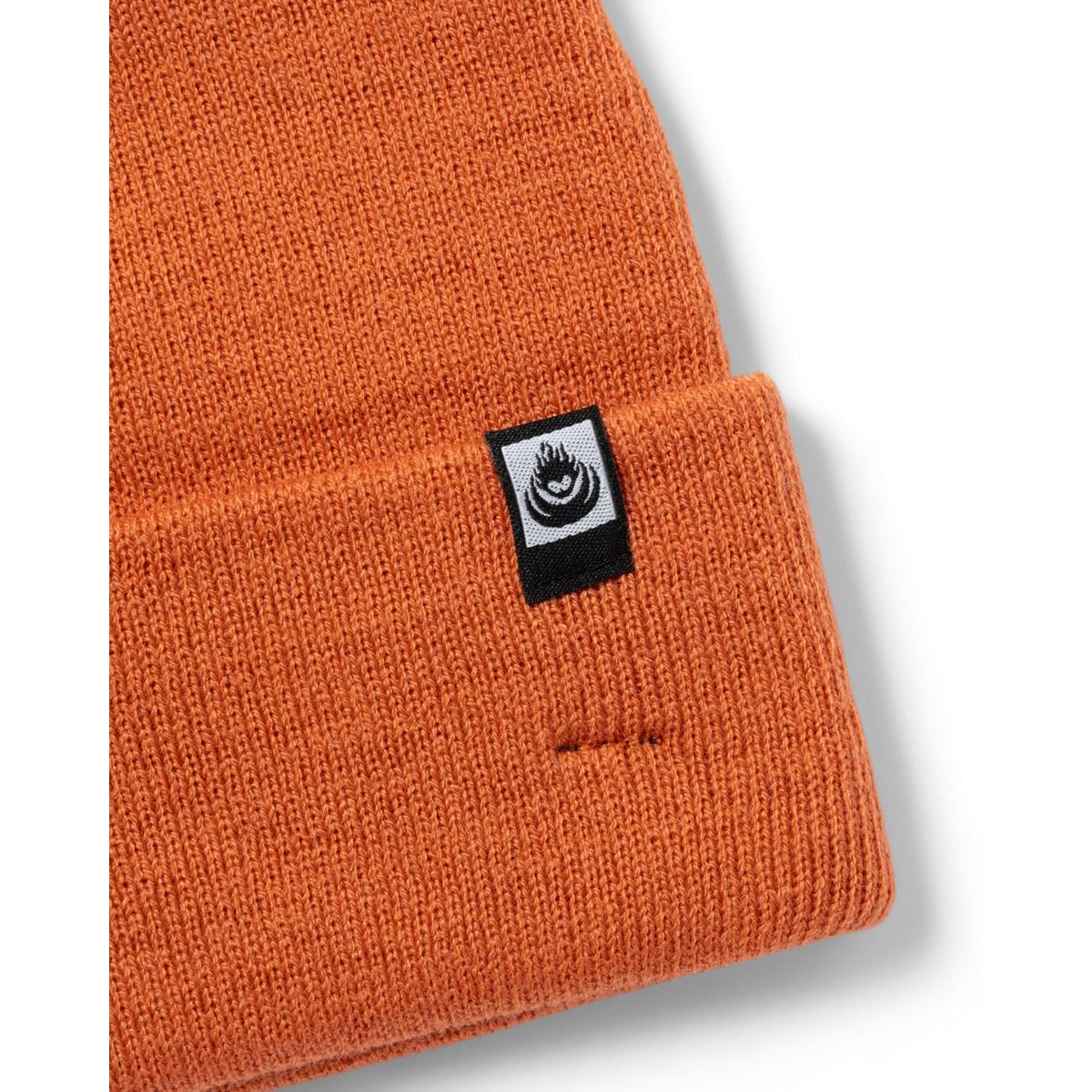 Close-up view of the turn back hem and logo label on a Saltrock OK beanie in light orange.