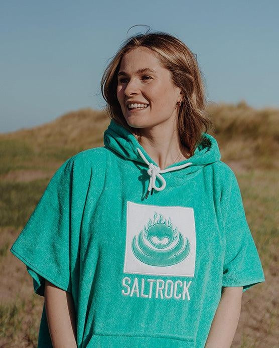 Woman wearing Saltrock Corp changing towel robe in Turquoise with hood outdoors on a sunny day