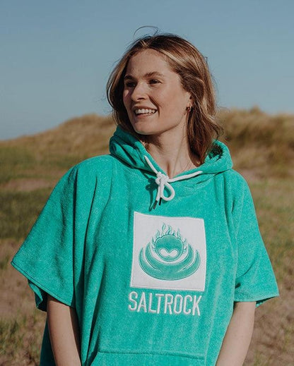 Woman wearing Saltrock Corp changing towel robe in Turquoise with hood outdoors on a sunny day
