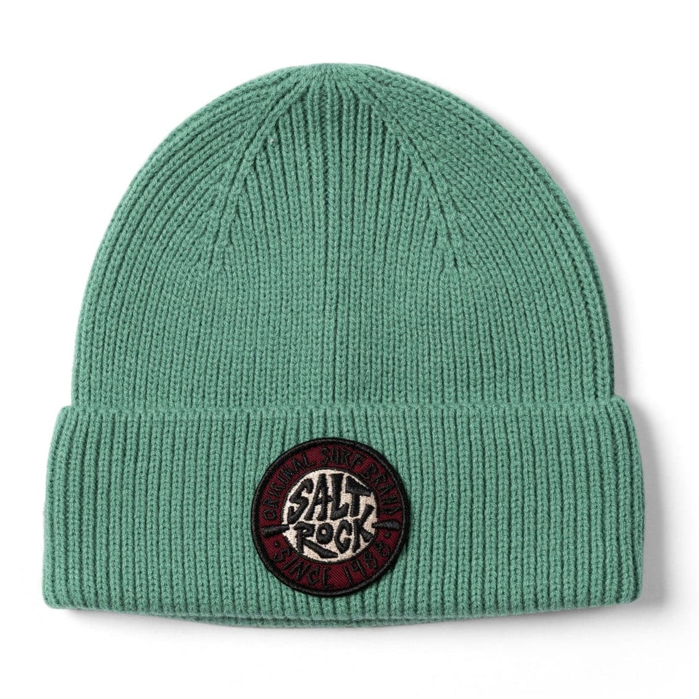 Front view of a Saltrock turquoise-green SR knitted beanie with a turn-up hem and round logo patch on a white background