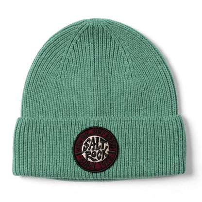 Front view of a Saltrock turquoise-green SR knitted beanie with a turn-up hem and round logo patch on a white background