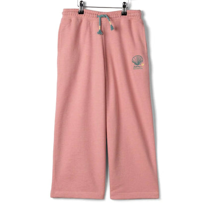 Front view of Saltrock kids Norie wide leg jogger trousers in pink with a drawcord waist and embroidered shell logo