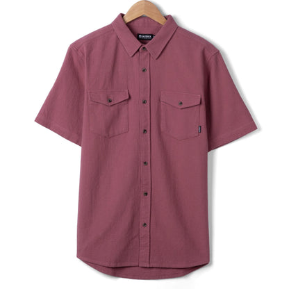 Front view of a Saltrock mens short sleeve Polperro shirt in dark pink with button through front and two button pockets on the chest with small logo on one pocket.