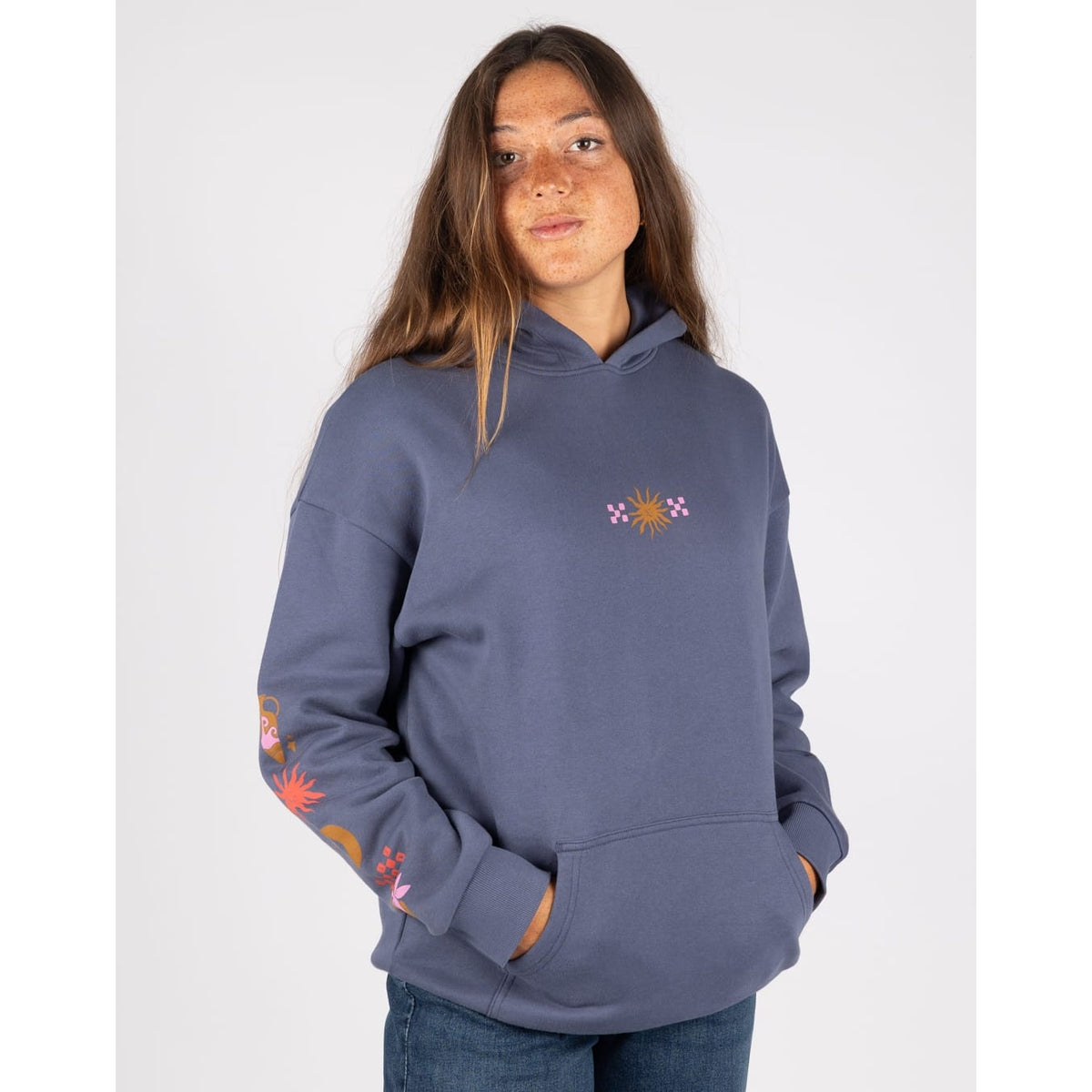 Front view of a woman wearing a Saltrock Athena pop hoodie in Dark Blue, featuring a tummy pocket, small print on the chest of sun and check pattern and another print along one sleeve.