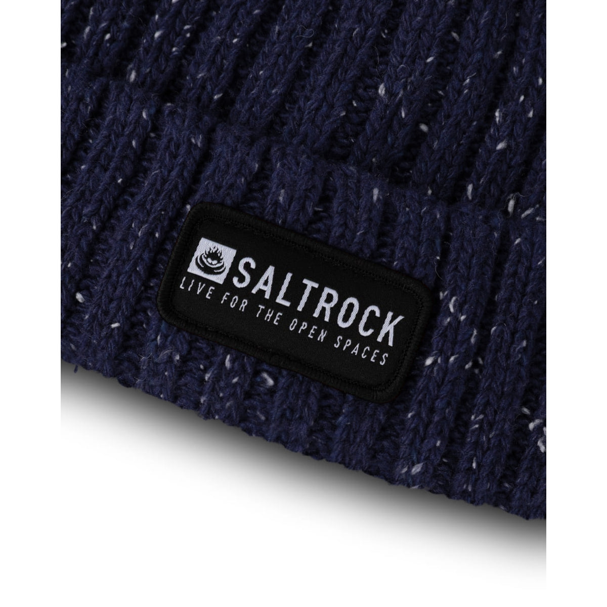 Close-up view of the logo patch, turn-up hem and ribbed knitted texture of a Saltrock adults Heritage beanie in navy with a white fleck.