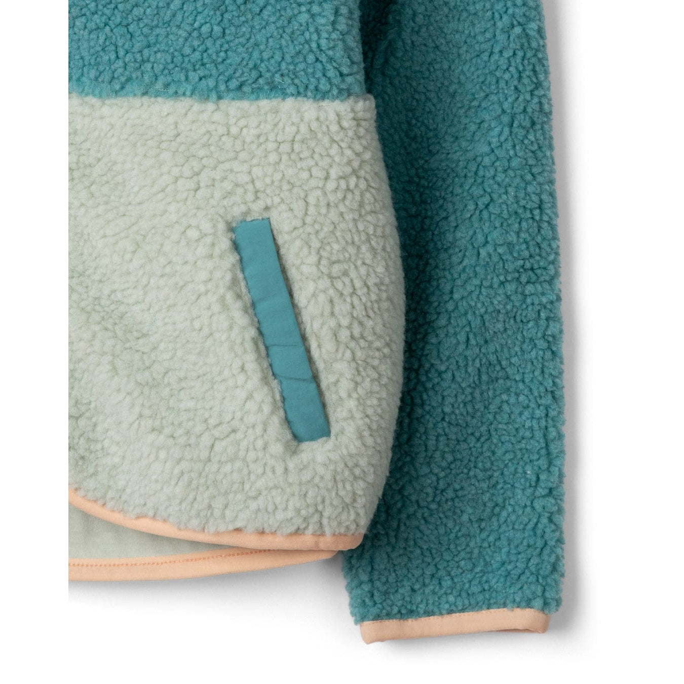 Close-up view of a tuummy pocket of a Saltrock kids Emery Wave fleece in turquoise teal and peach