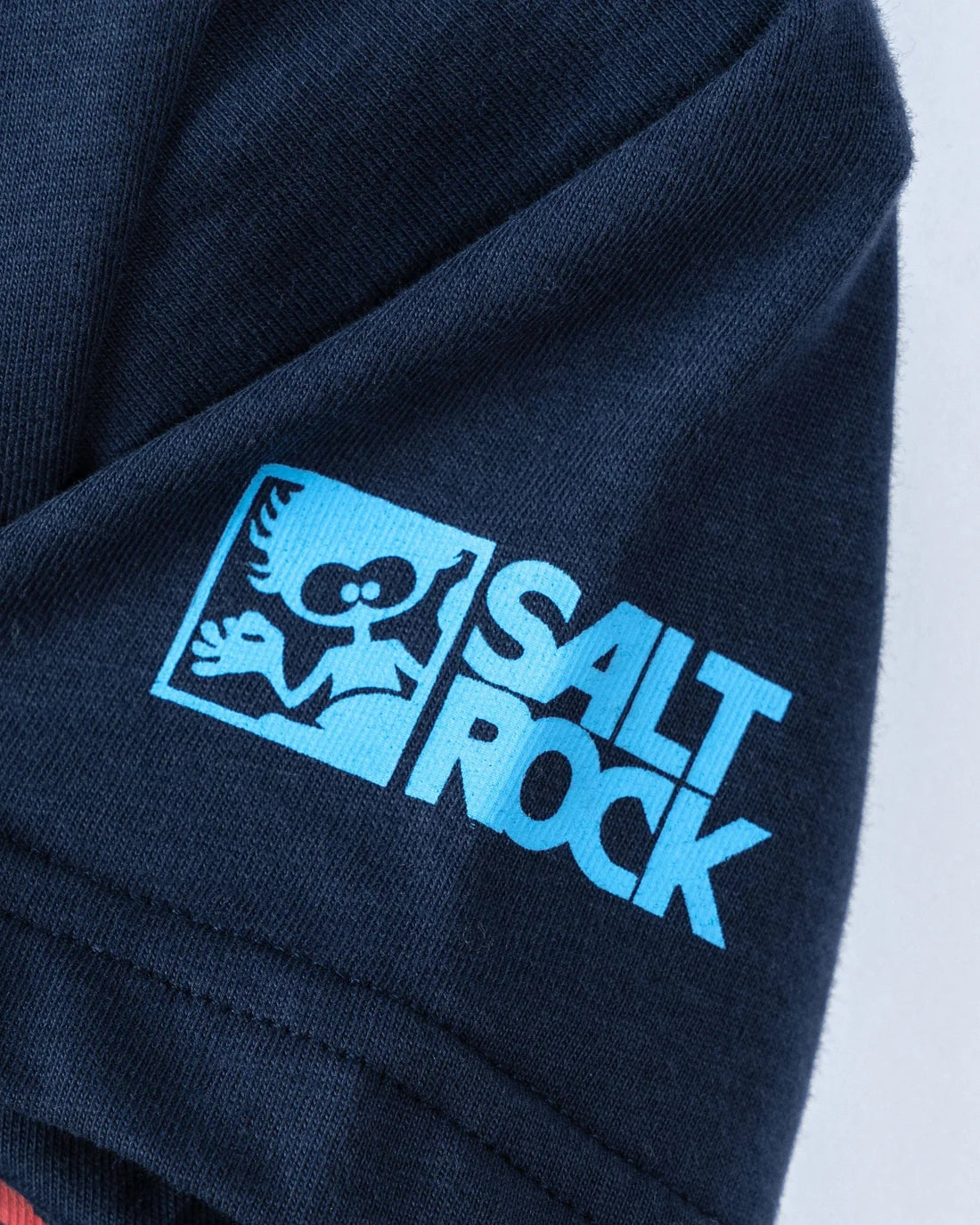 Close-up of Saltrock kids stripe tee blue sleeve with light blue Saltrock logo print