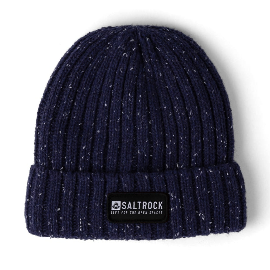 Main front view of a Saltrock adults Heritage beanie in navy with a white fleck, ribbed knit texture, faux fur lining and a turnup hem with logo patch.