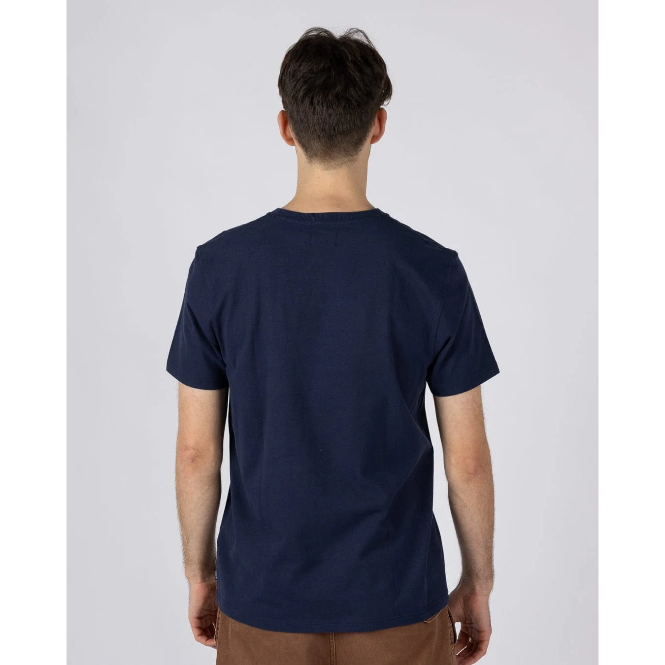 Back view of a man wearing a Saltrock short sleeve Tribal Stripe t-shirt in navy, with a multicoloured stripe print across the chest.