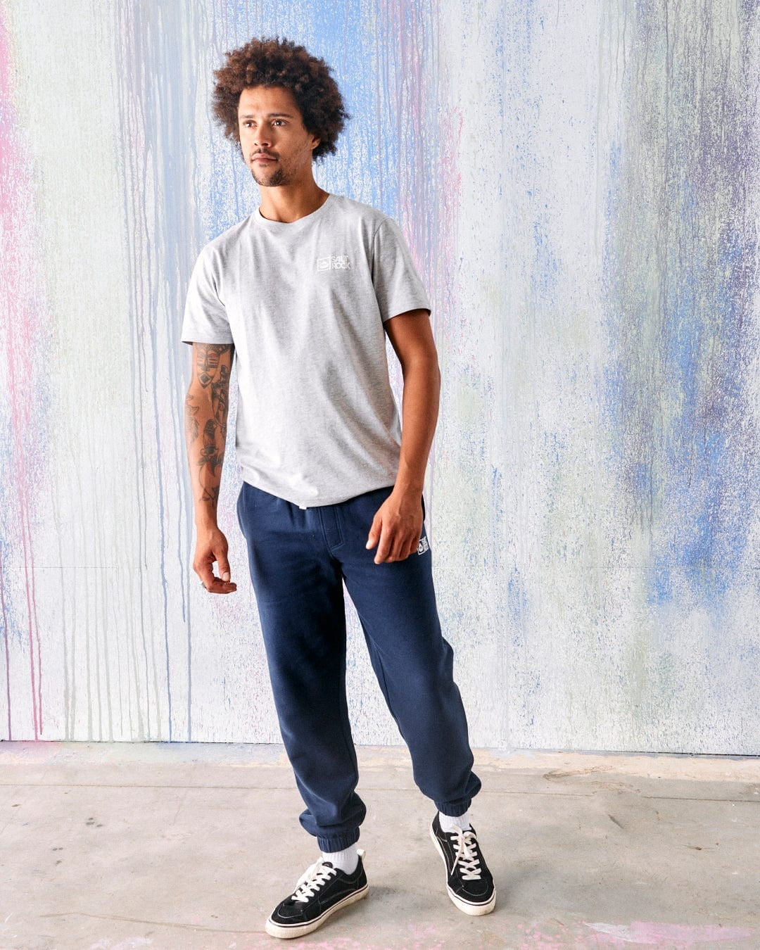 A man wearing a pair of Saltrock blue marl jogger trousers with a light grey t-shirt