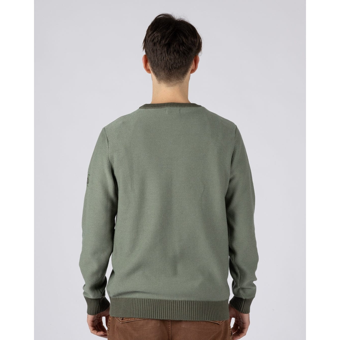 Back view of a man wearing a green Saltrock knitted Callum jumper with ribbed neckline, cuffs and bottom hem