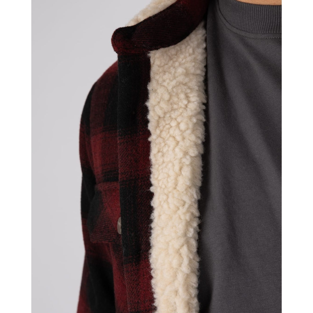 Close-up view of the cream Borg lining of a  Saltrock Fisher dark red check pattern shacket.