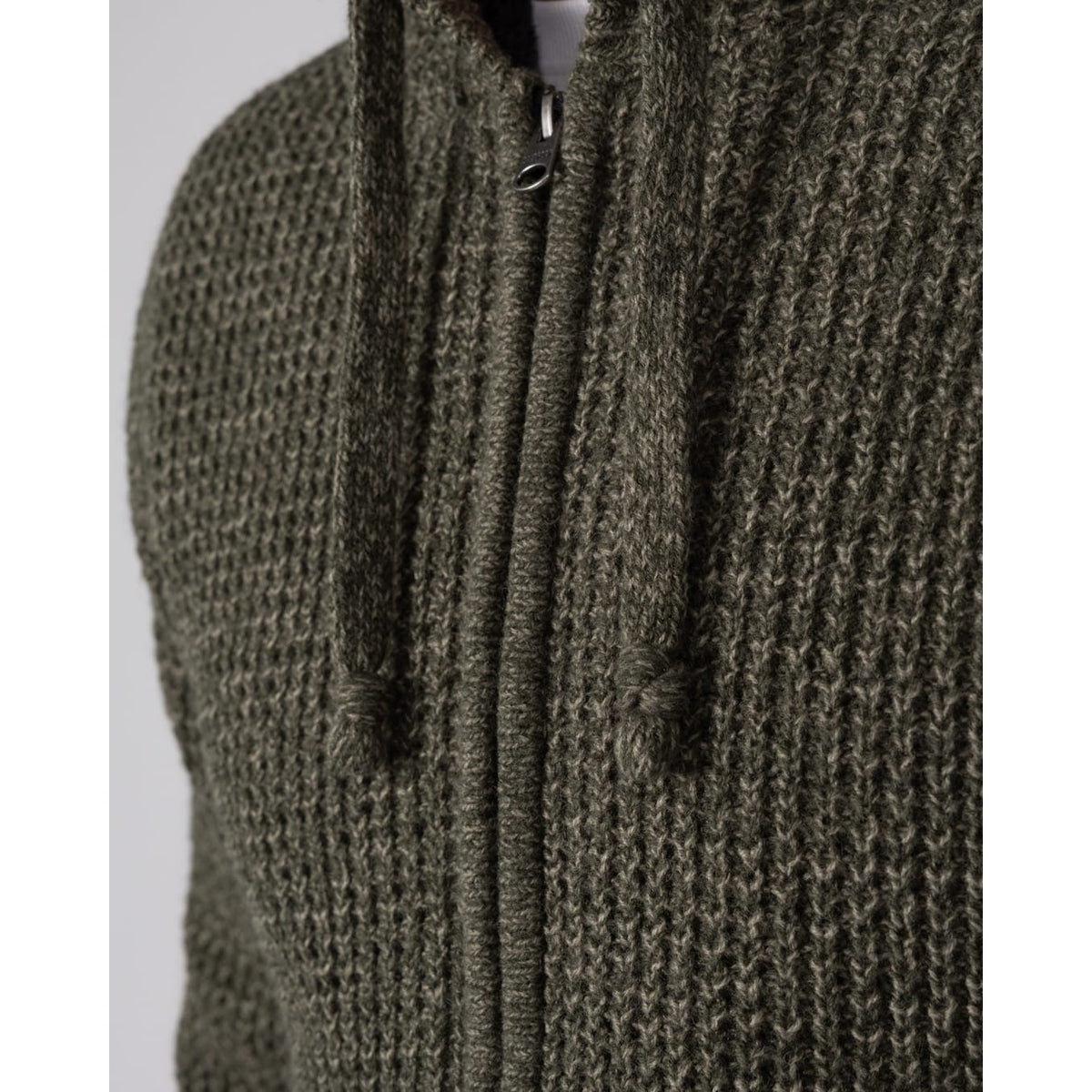 Close-up view of the zip and chunky knitted outer fabric of a Saltrock dark green Markus zip hoodie.