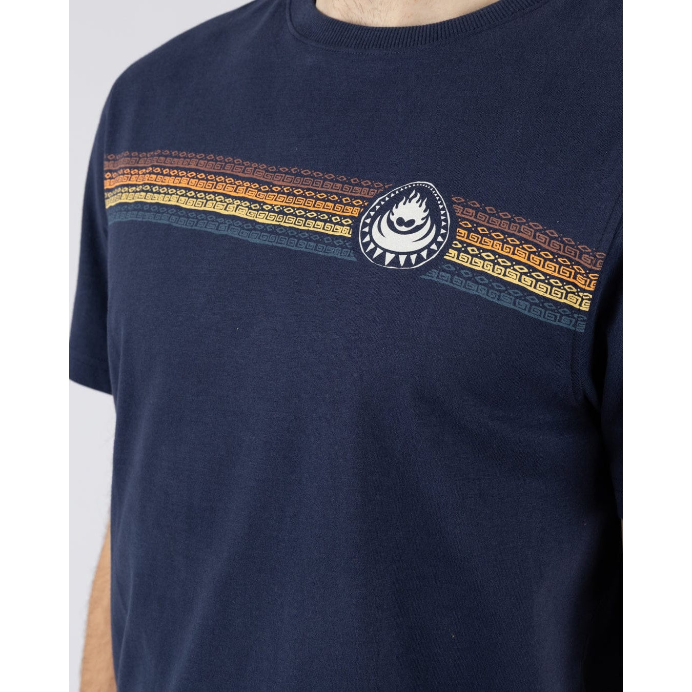 Close-up view of a multicoloured 'tribal-style' stripe print across the chest of a Saltrock short sleeve Tribal Stripe t-shirt in navy.