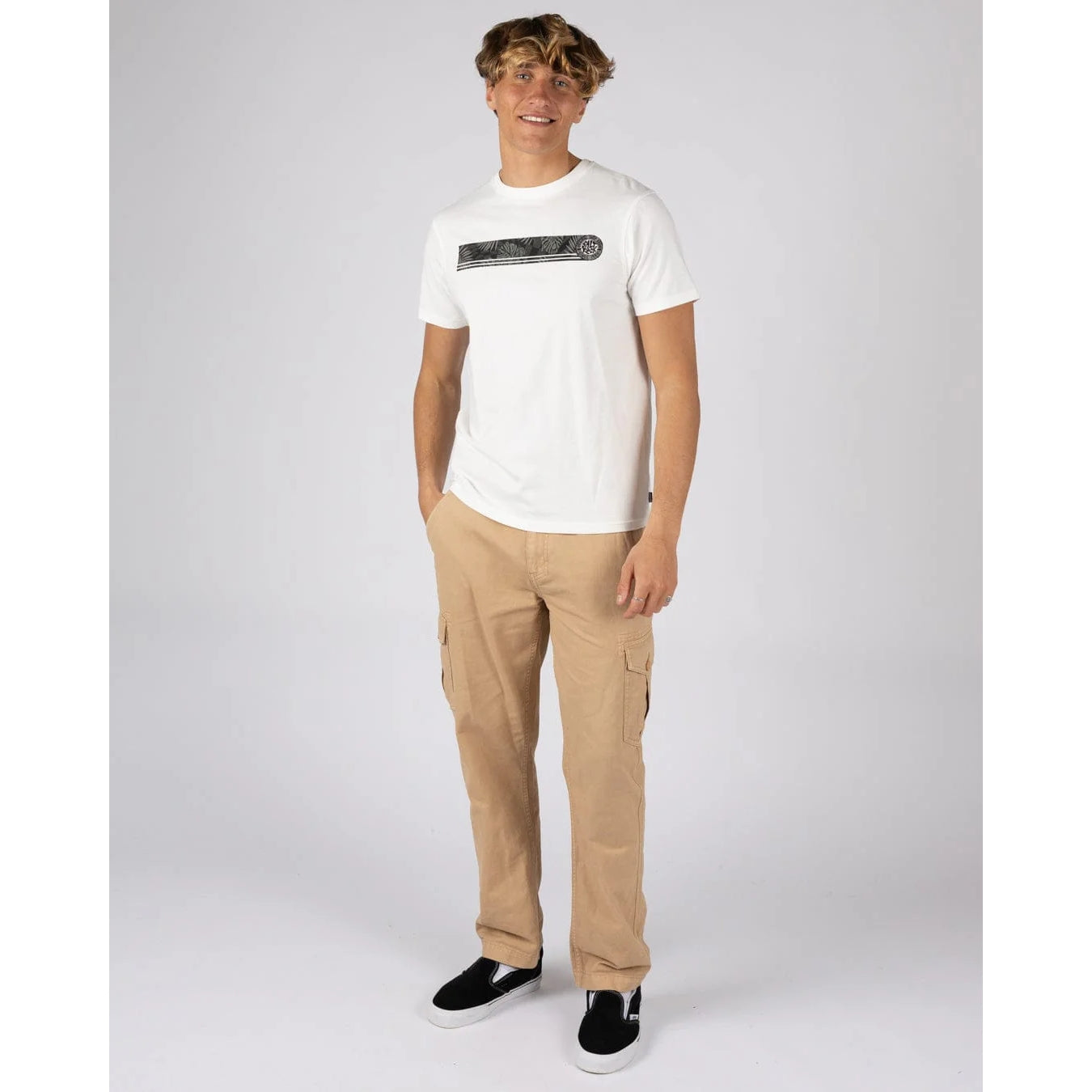Man wearing a Saltrock short sleeve Warp Surf Stripe t-shirt in cream with print across the chest and tan trousers