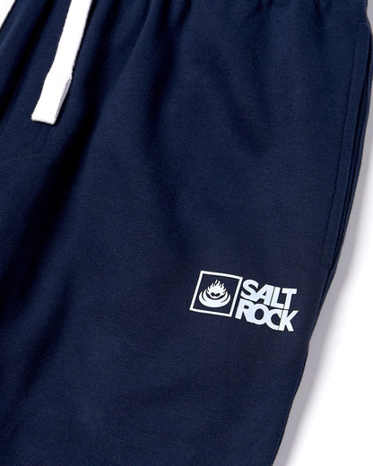 Close up of a Saltrock printed logo on a pair of mens jogger sweat trousers in dark blue on a white background