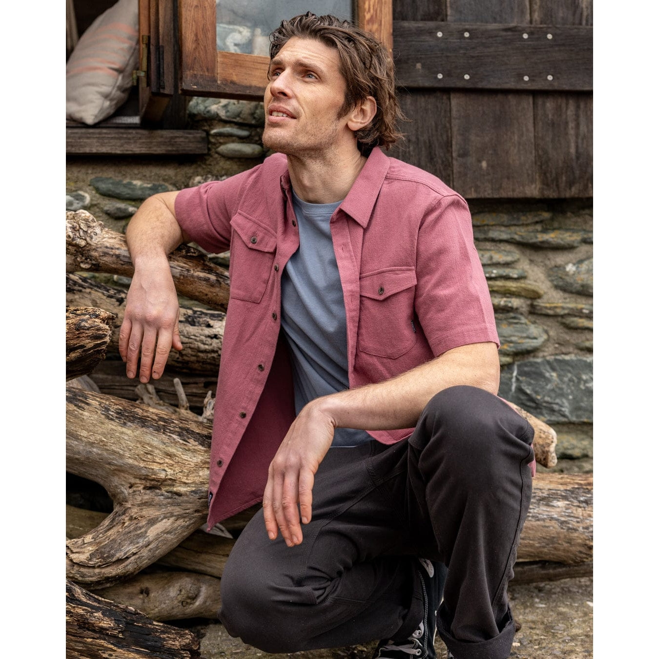 Man wearing a Saltrock short sleeve Polperro shirt in dark pink with button through front and two button pockets on the chest.