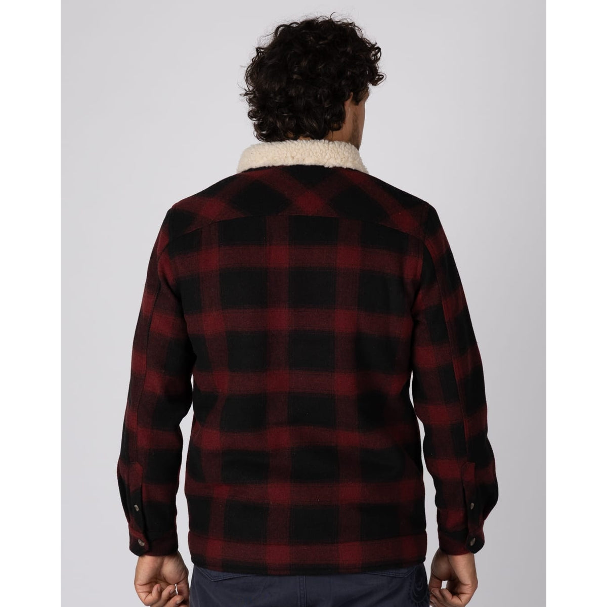 Back view of a man wearing a red and black Saltrock Fisher Borg lined shacket with cream borg collar.
