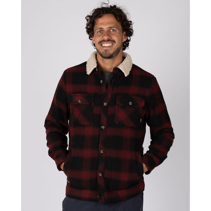 Front view of a man wearing a red and black Saltrock Fisher Borg lined shacket with two pockets on the chest and open pockets on the tummy.