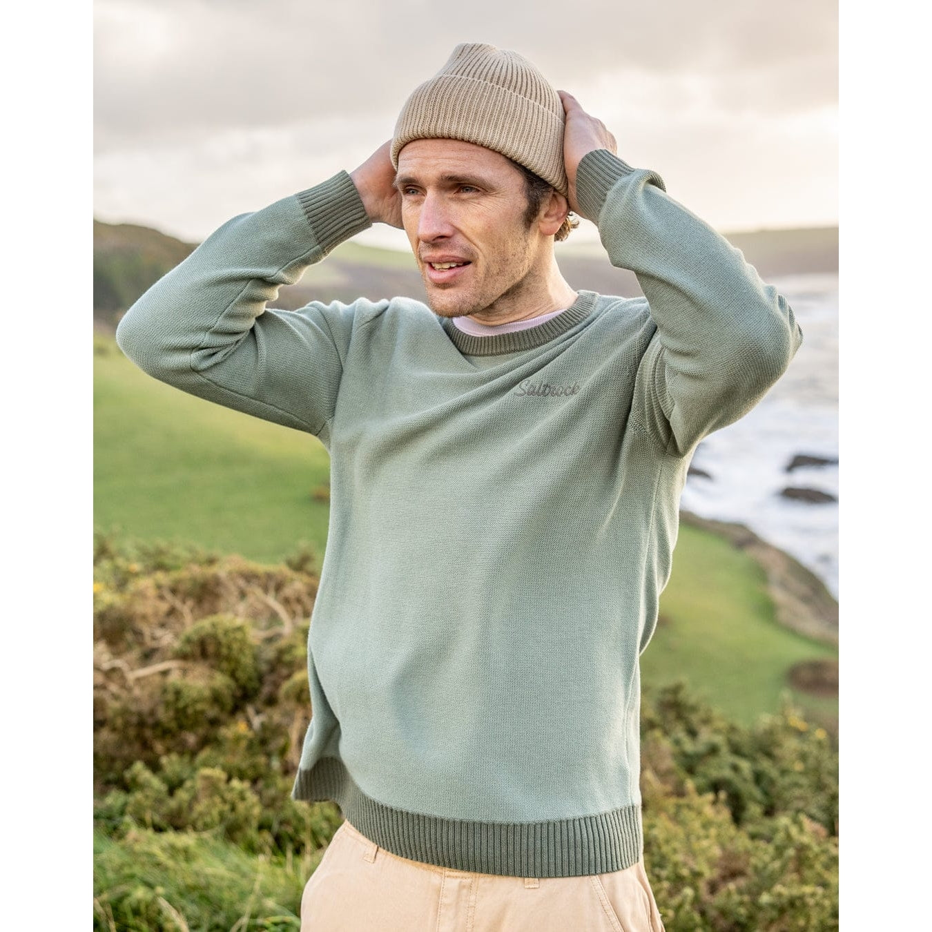 Front view of a man wearing a green Saltrock knitted Callum jumper with round neckline, ribbed cuffs, hem and neckline trim