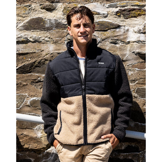 Front view of a man wearing a Saltrock Rafe colour block zip fleece in black and beige.