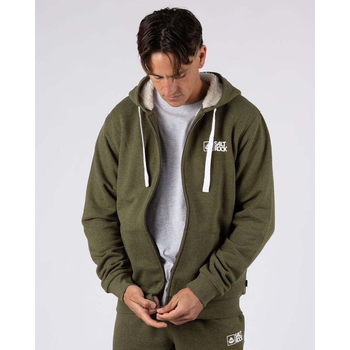 Front view of a man wearing a Saltrock Essential full zip faux fur lined hoodie in khaki green unzipped.
