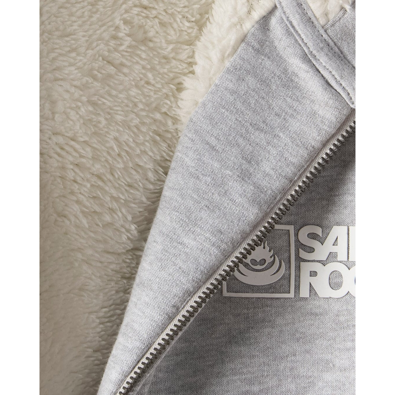 Close-up of a grey faux fur lined Saltrock hoodie with a zipper and visible brand logo on a neutral background.