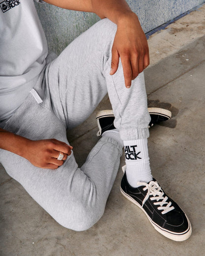 Close up of a man sat on the floor wearing a pair of Saltrock grey marl Original jogger sweat trousers