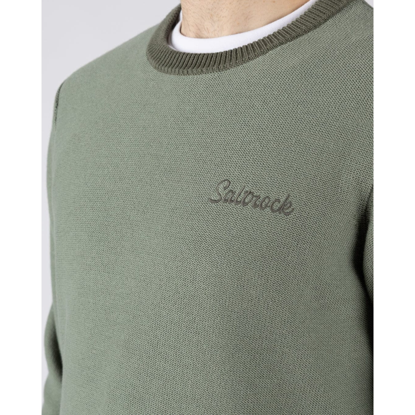 Close-up view of a mens Saltrock green Callum knitted jumper with logo embroidered on the chest and ribbed neckline