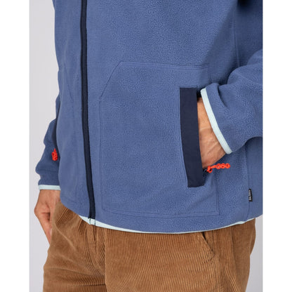 Close-up view of the tummy pockets on a Saltrock full zip Leo fleece in blue with navy, turquoise and red trim.