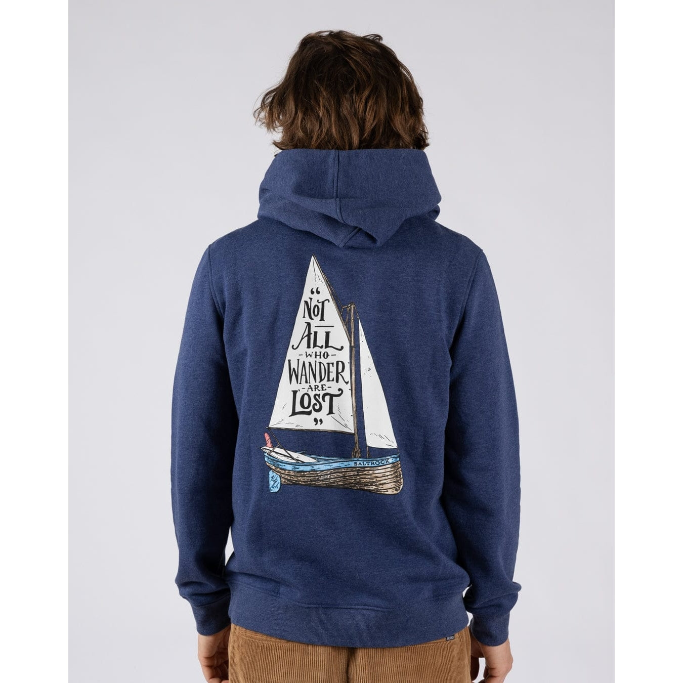 Main view of a man wearing a Saltrock Lost Ships pop hoodie in blue featuring a sail boat print with the quote "Not all who Wander are Lost"