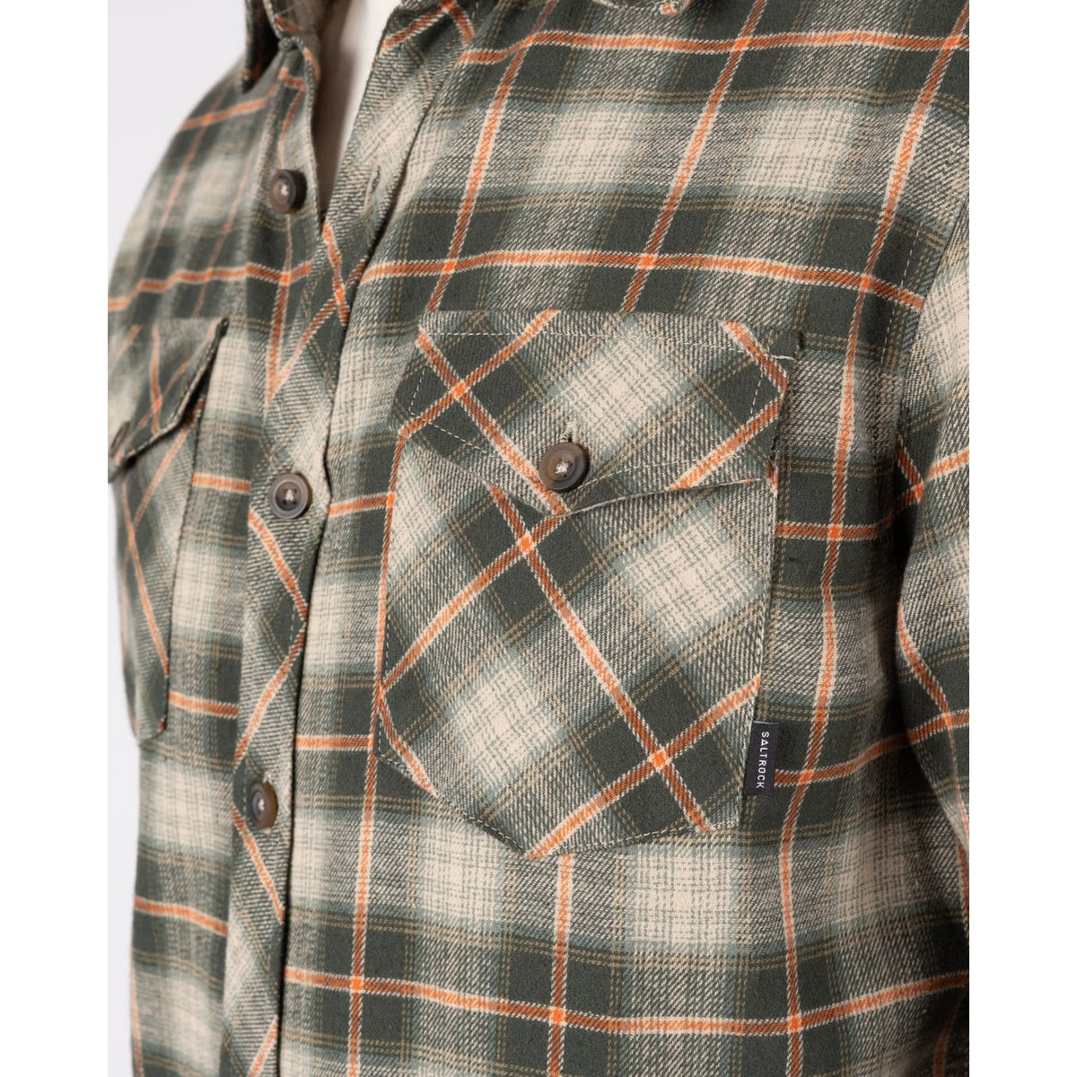 Close-up view of the chest pockets on a mens Saltrock long sleeve Miles flannel shirt in a green and orange check pattern.
