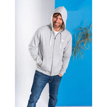 Man wearing a grey Saltrock faux fur lined zip hoodie with a logo, standing against a blue wall.