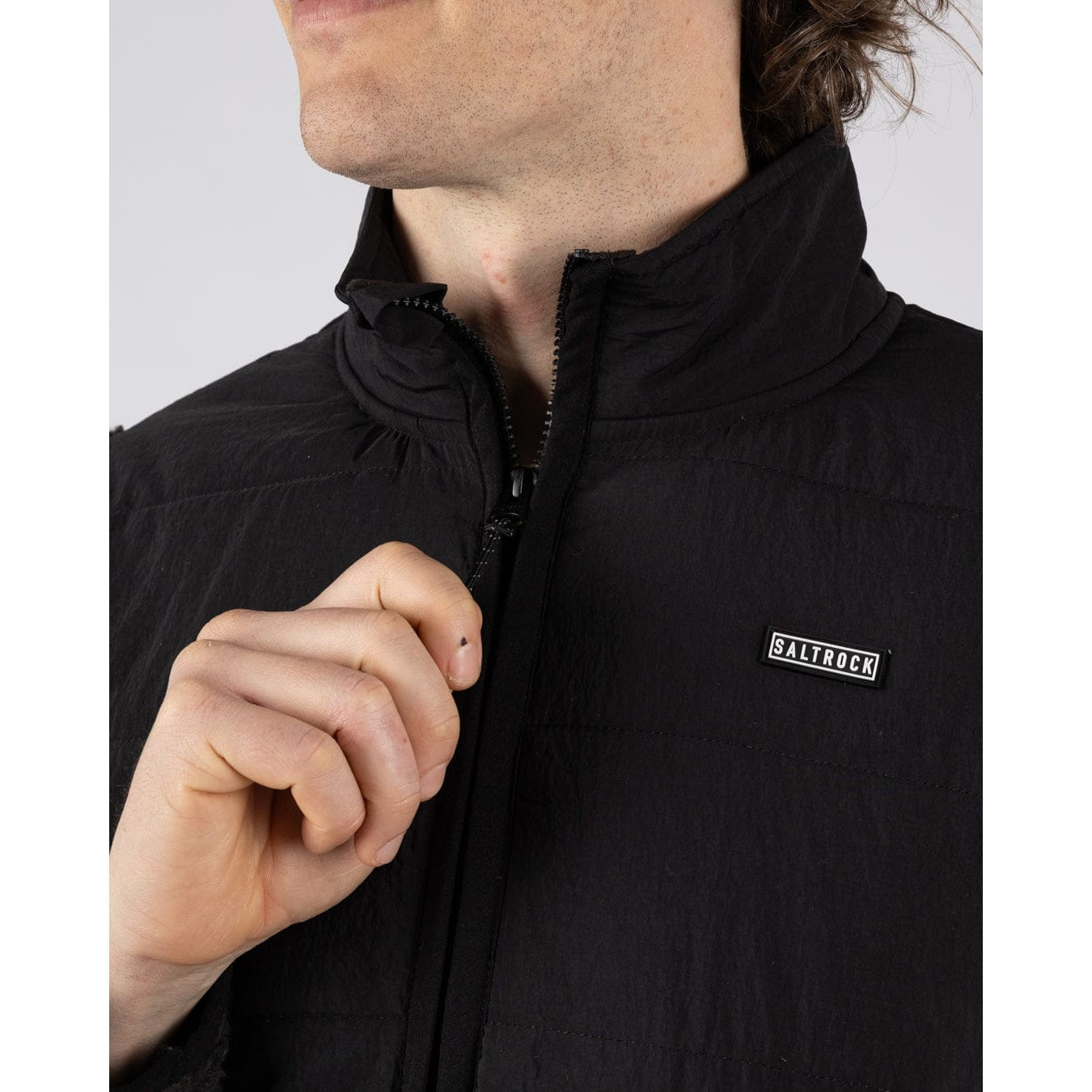 Close-up view of the zip of a Saltrock Rafe fleece in black and beige