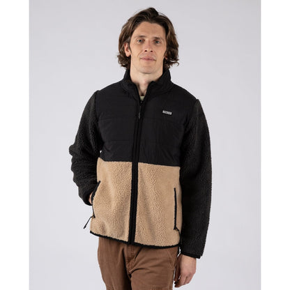 Front view of a man wearing a black and beige two tone Saltrock Rafe zip fleece