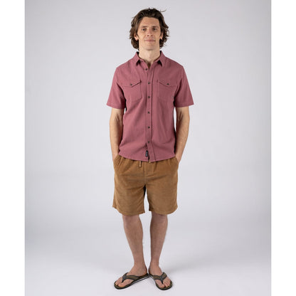 Man wearing a Saltrock dark pink short sleeve Polperro button through shirt with brown shorts and flip flops