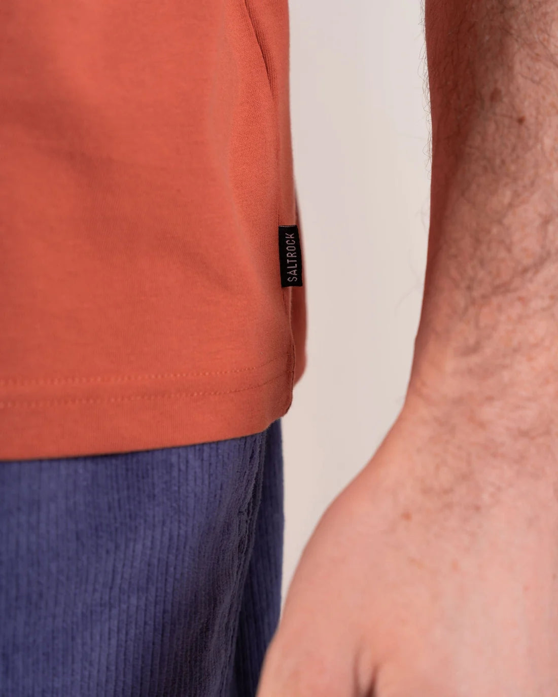 Close-up of Saltrock mens t-shirt orange label on the side, showcasing soft fabric and casual style