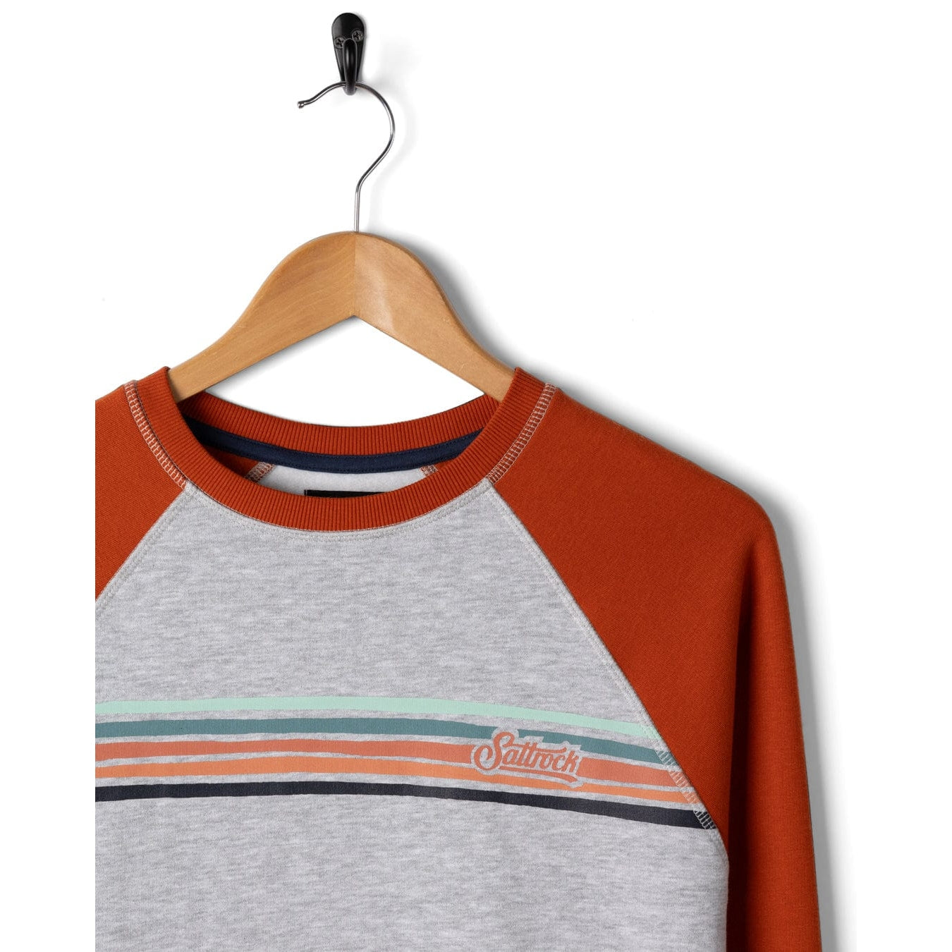 Sweatshirt with orange sleeves and grey body on a hanger against a white background