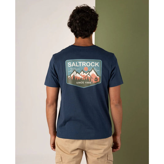 Man wearing a navy blue t-shirt with a 'Saltrock' logo on the back against a neutral background