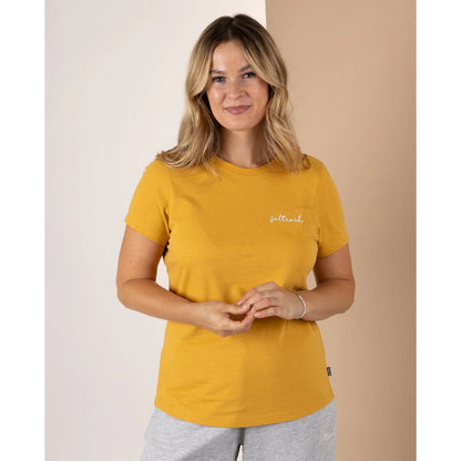 Front view of a Saltrock womens Velator t-shirt in gold yellow on smiling woman short sleeve crew neck tee with small chest logo