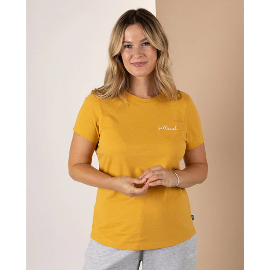 Front view of a Saltrock womens Velator t-shirt in gold yellow on smiling woman short sleeve crew neck tee with small chest logo