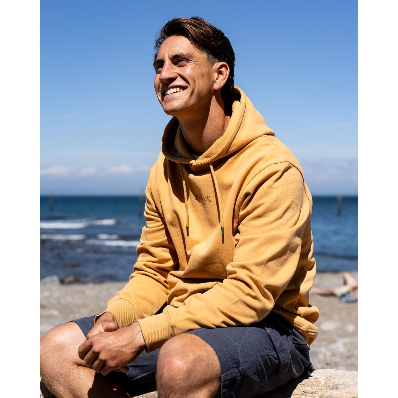 Side view of a man wearing a Saltrock Open Finals Linear pop hoodie in yellow