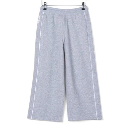 Back view of kids Saltrock Tok Corp jogger trousers in grey with elasticated drawstring waist with white piping down the side of the legs.